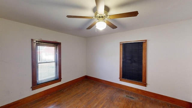 empty room with dark wood-type flooring and ceiling fan