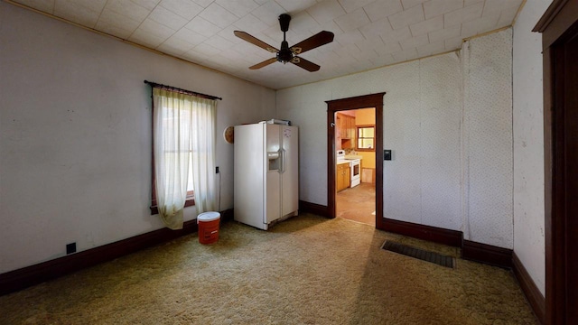 carpeted spare room featuring ceiling fan