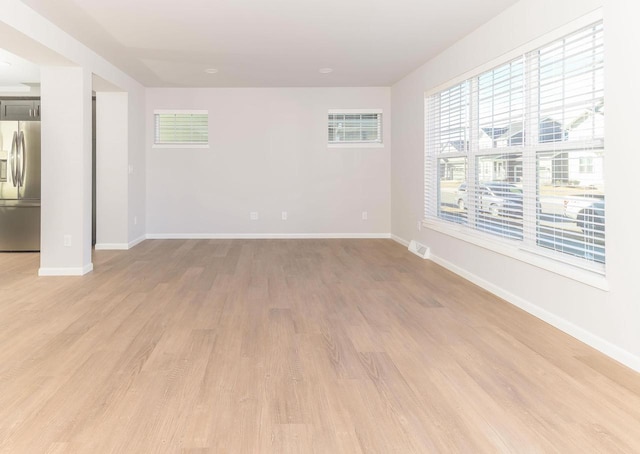 unfurnished room with a wall unit AC and light wood-type flooring