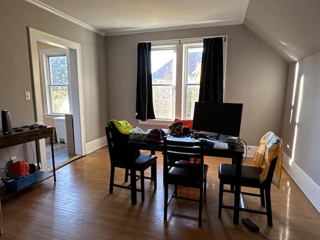 dining room featuring lofted ceiling, hardwood / wood-style floors, and crown molding