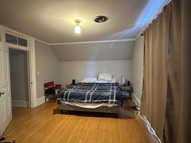 bedroom with vaulted ceiling and wood-type flooring