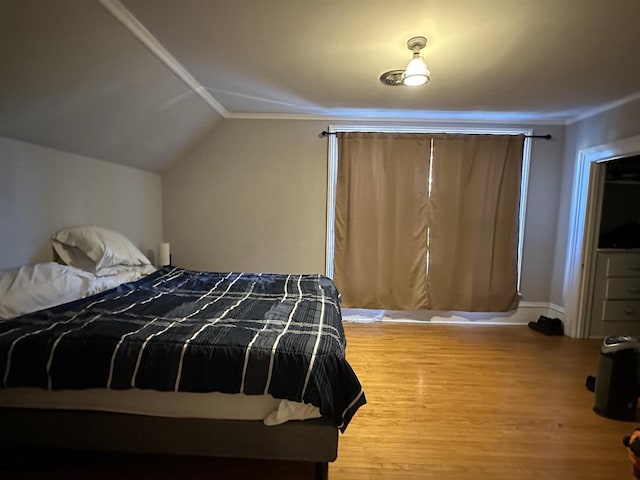 bedroom featuring wood-type flooring and vaulted ceiling