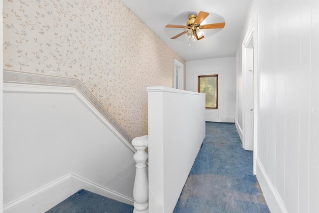 stairs featuring ceiling fan and carpet floors