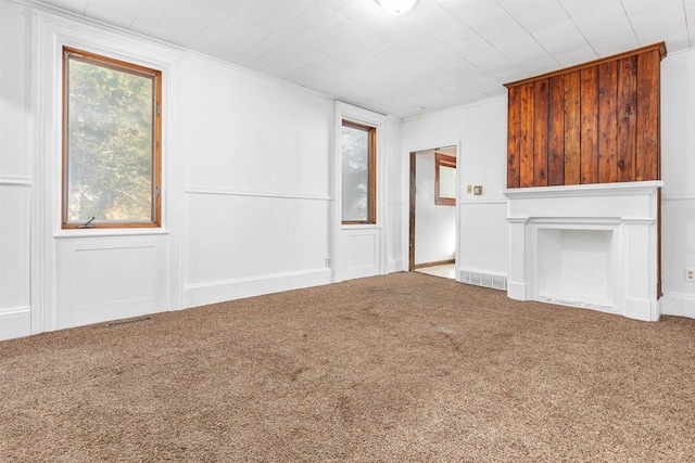 unfurnished living room featuring crown molding and carpet