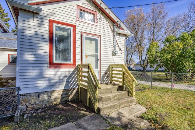 view of exterior entry with a lawn