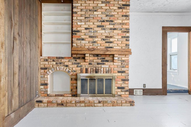 unfurnished living room featuring hardwood / wood-style flooring and a brick fireplace