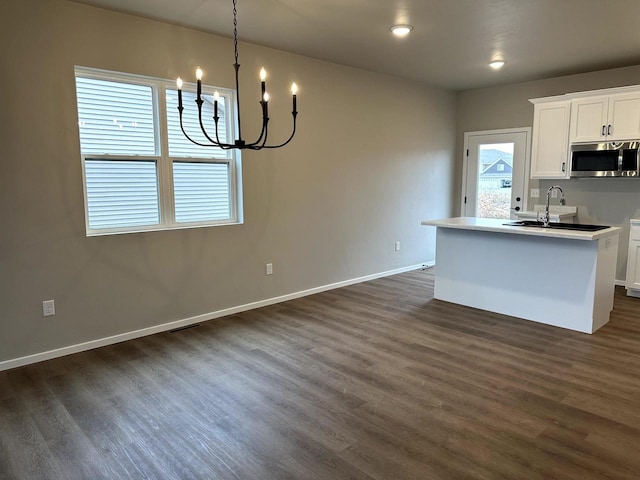 kitchen with white cabinetry, dark wood-type flooring, and a notable chandelier