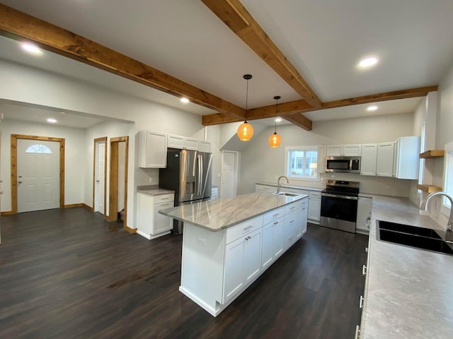 kitchen featuring hanging light fixtures, stainless steel appliances, sink, light stone countertops, and white cabinets