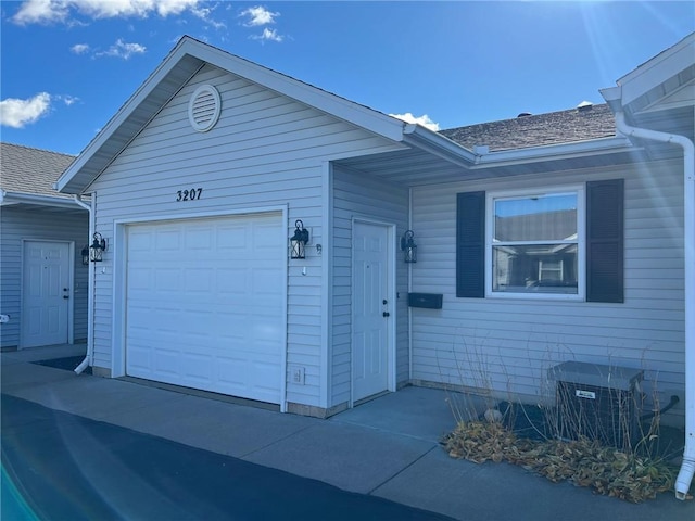 single story home featuring central AC and a garage