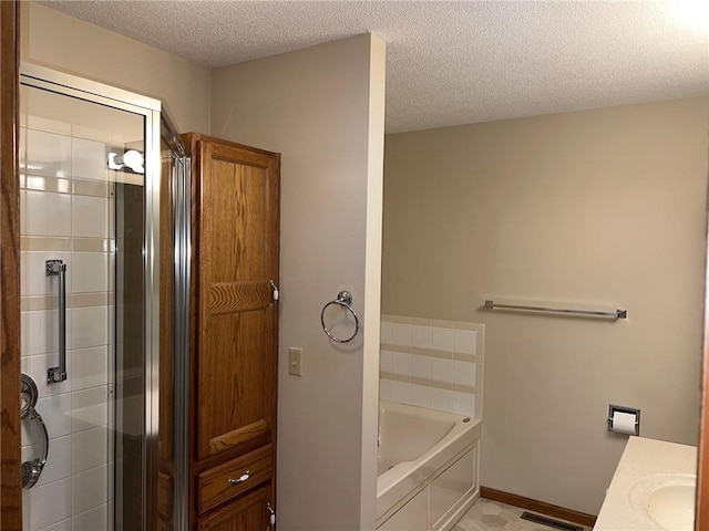 bathroom with vanity, a textured ceiling, and plus walk in shower