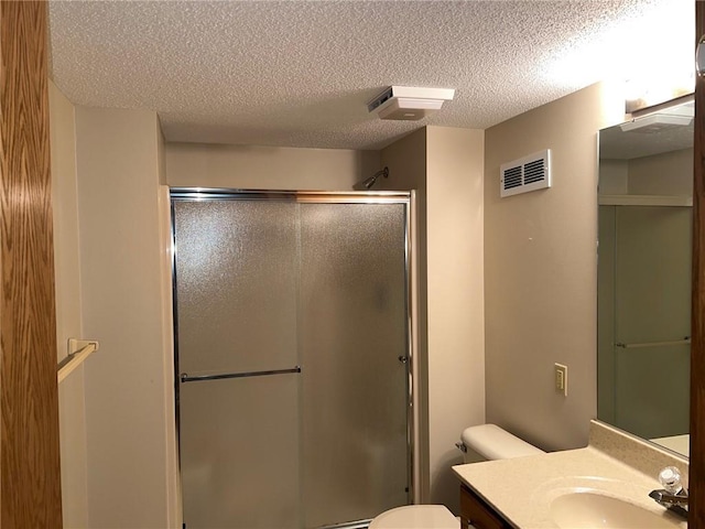 bathroom featuring vanity, a textured ceiling, toilet, and an enclosed shower