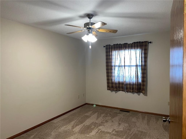 carpeted spare room featuring a textured ceiling and ceiling fan