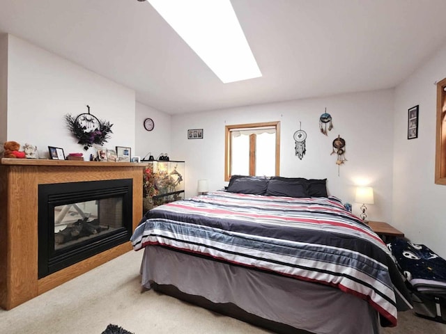 bedroom featuring a multi sided fireplace, carpet flooring, and a skylight