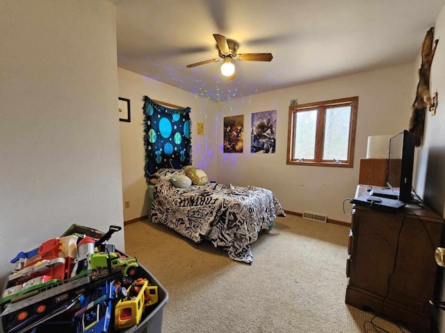 carpeted bedroom with visible vents, a ceiling fan, and baseboards