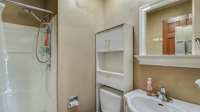 bathroom with sink, toilet, and walk in shower