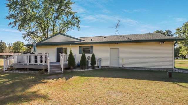 rear view of property featuring a wooden deck and a yard