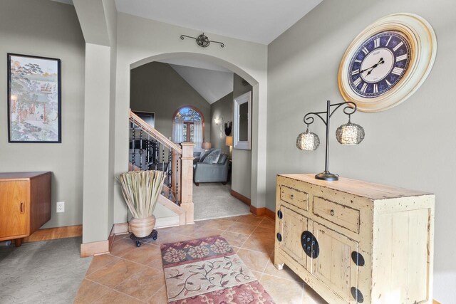 tiled entryway featuring vaulted ceiling