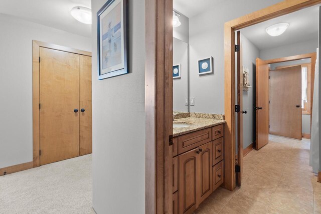 corridor with light colored carpet and sink