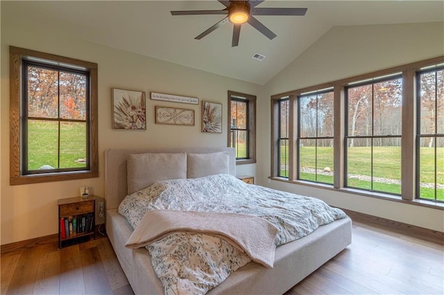 bedroom with wood-type flooring, ceiling fan, lofted ceiling, and multiple windows