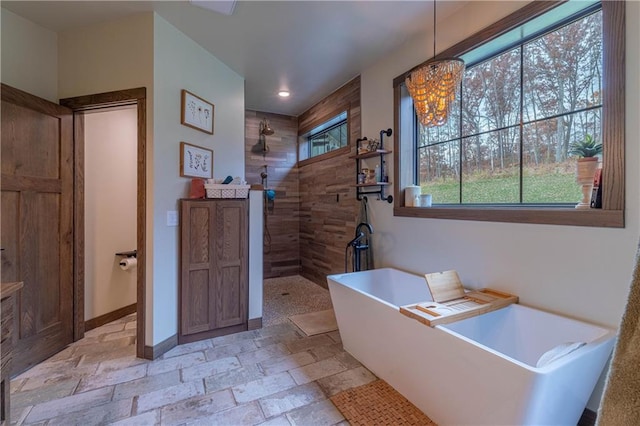 bathroom with shower with separate bathtub and a notable chandelier