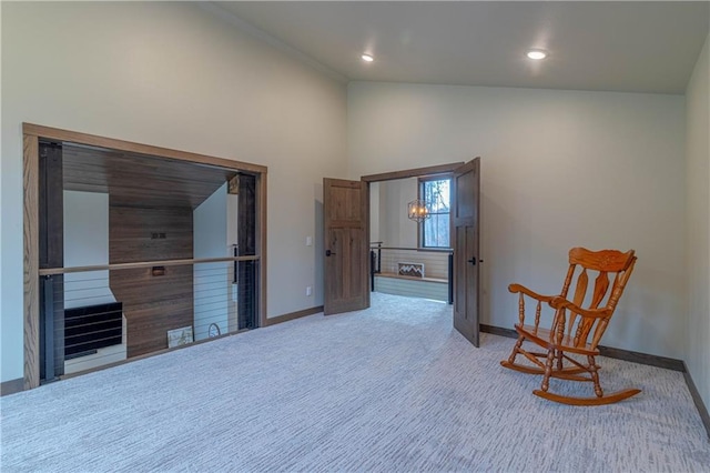 sitting room with an inviting chandelier, carpet floors, and high vaulted ceiling