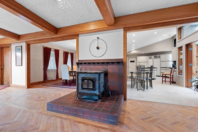 living room with tile patterned floors, a wood stove, and a textured ceiling