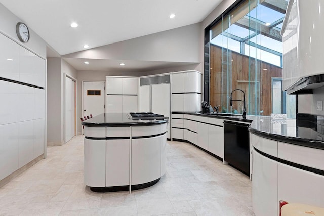 kitchen featuring vaulted ceiling with skylight, dishwasher, a kitchen island, and white cabinets