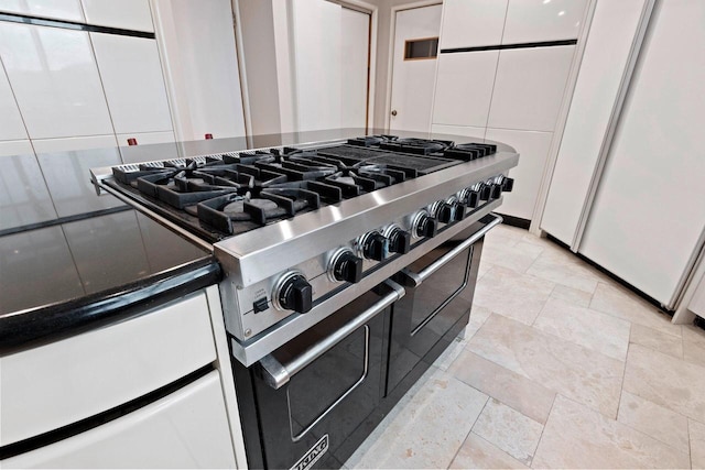 details with backsplash, white cabinetry, white fridge, and high end stainless steel range oven