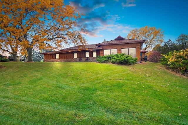 back house at dusk with a lawn