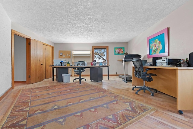 office area featuring light hardwood / wood-style floors and a textured ceiling