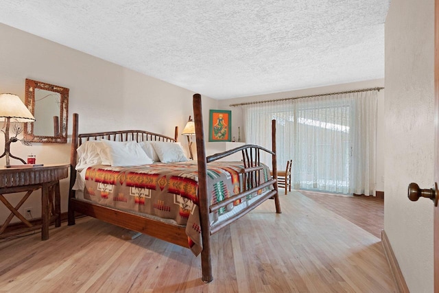 bedroom with a textured ceiling and light wood-type flooring