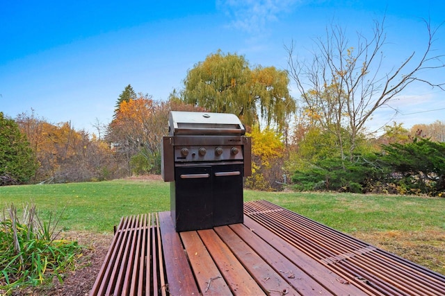 wooden terrace with a yard and a grill