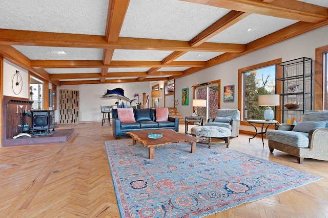 living room with a wood stove, a textured ceiling, light parquet floors, coffered ceiling, and beam ceiling