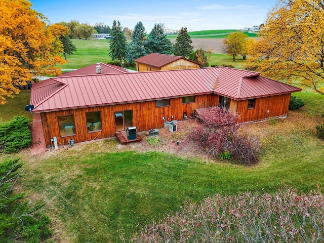 back of house featuring a yard and a rural view