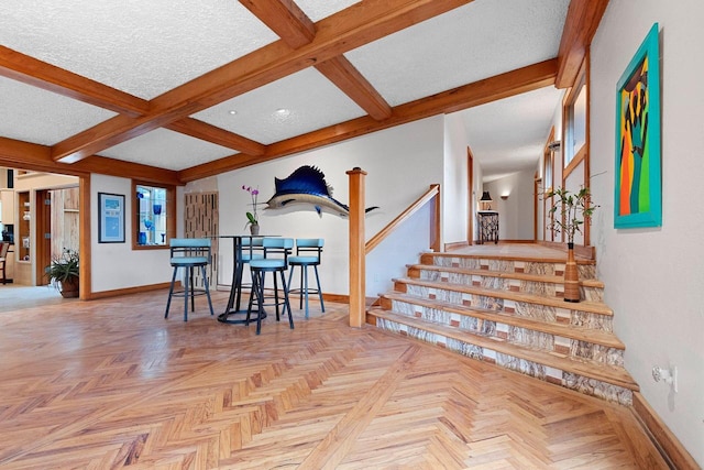 dining room with beamed ceiling, coffered ceiling, a textured ceiling, and light parquet flooring