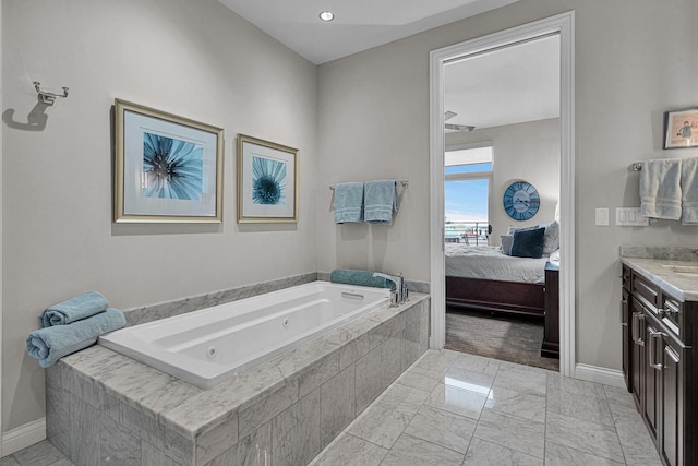 bathroom with vanity and tiled tub