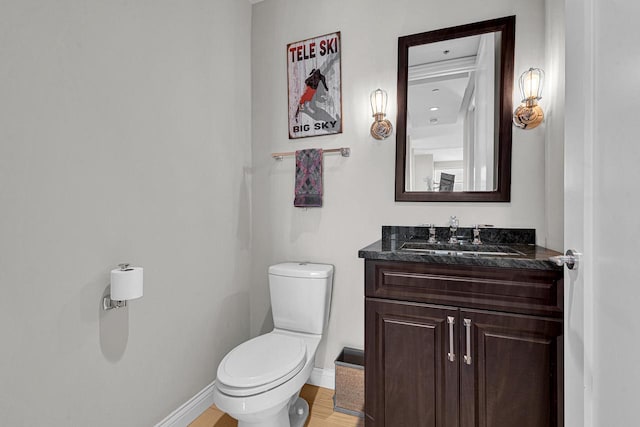 bathroom with vanity, toilet, and hardwood / wood-style floors