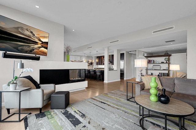 living room featuring a multi sided fireplace and dark hardwood / wood-style floors