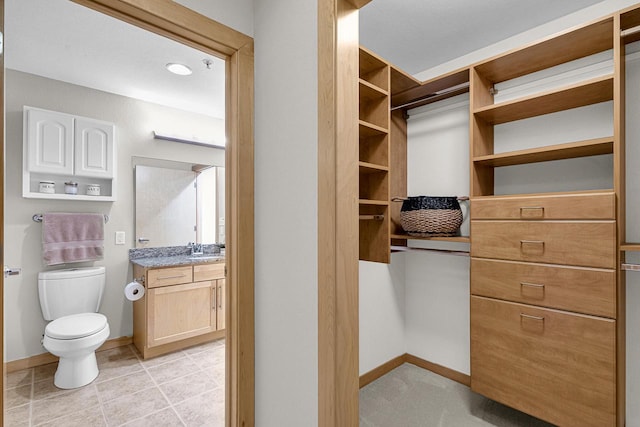 spacious closet with sink and light tile patterned flooring