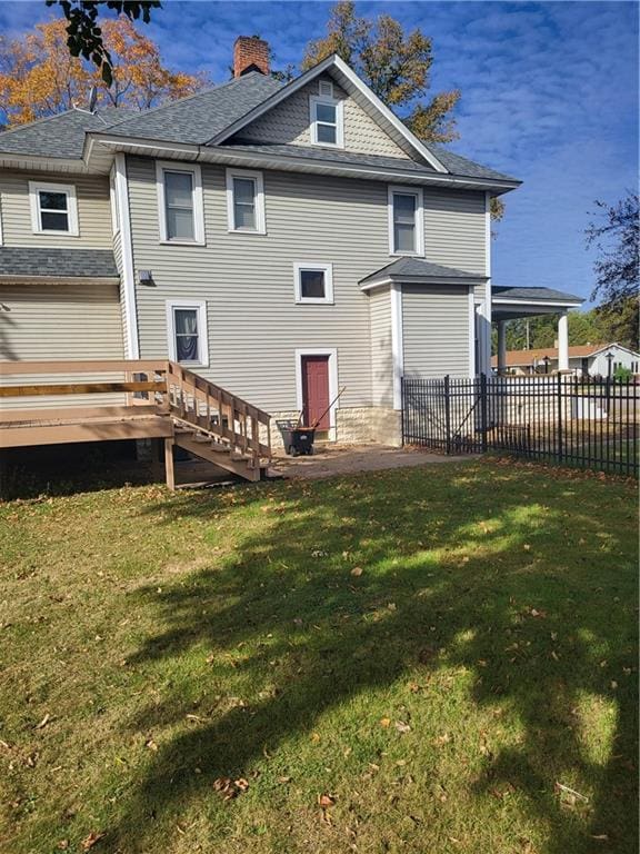 back of house featuring a yard and a wooden deck