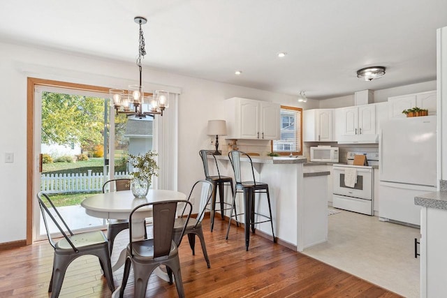 dining room featuring an inviting chandelier and light hardwood / wood-style flooring