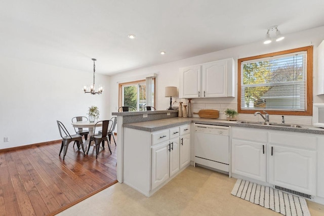 kitchen with kitchen peninsula, white cabinets, hanging light fixtures, light wood-type flooring, and white appliances