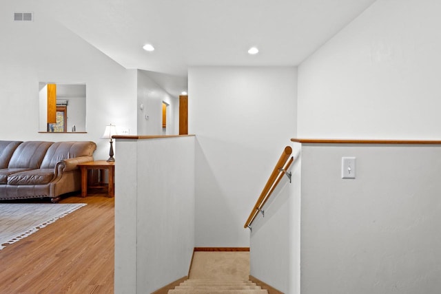 staircase with a barn door and wood-type flooring