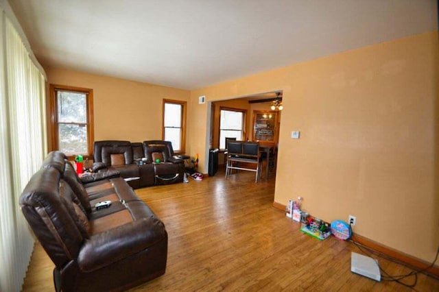 living room with a wealth of natural light, hardwood / wood-style floors, and a notable chandelier