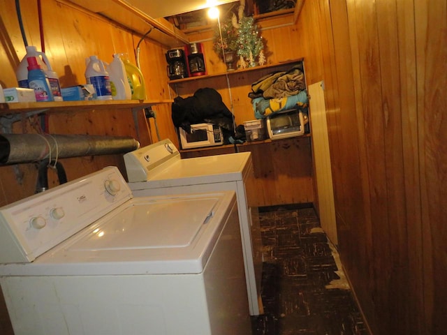 washroom featuring wood walls and washing machine and clothes dryer