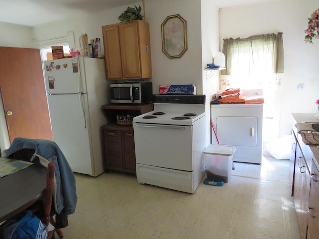 kitchen with white appliances and washer / clothes dryer