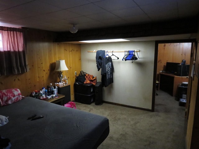 carpeted bedroom featuring wooden walls