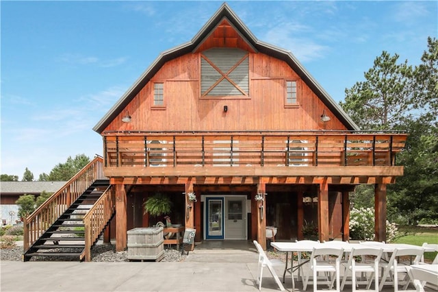 rear view of property featuring a patio area and a wooden deck