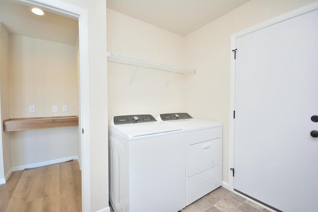 washroom featuring washing machine and clothes dryer and light wood-type flooring