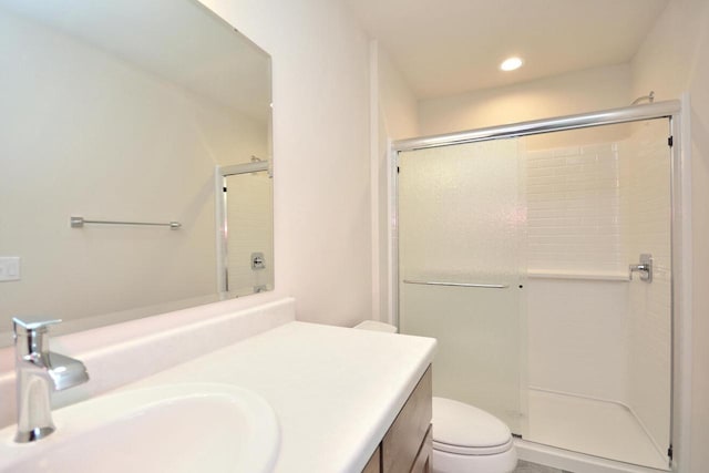 bathroom featuring walk in shower, vanity, and toilet